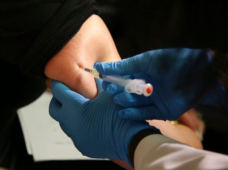 a woman receives a measles, mumps and rubella vaccine