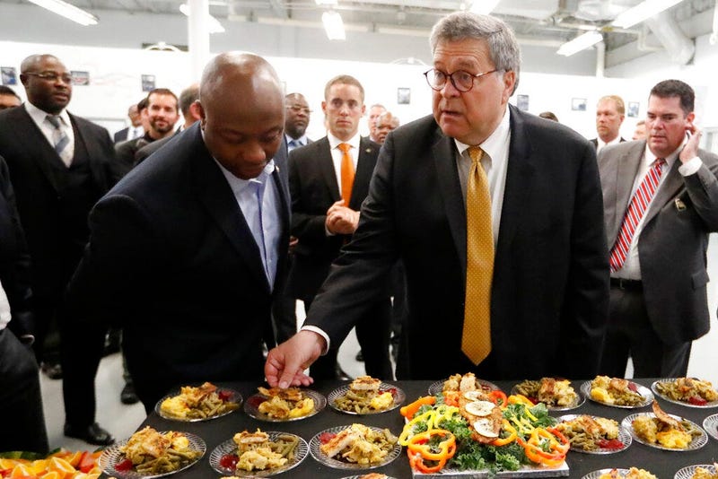 Attorney General William Barr, right, and Sen, Tim Scott, R-S.C., sample food prepared by an inmate culinary arts class during a tour of a federal prison Monday, July 8, 2019, in Edgefield, S.C. 