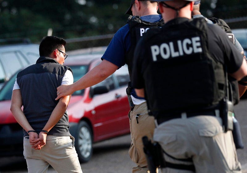 A man is taken into custody at a Koch Foods Inc. plant in Morton, Miss.