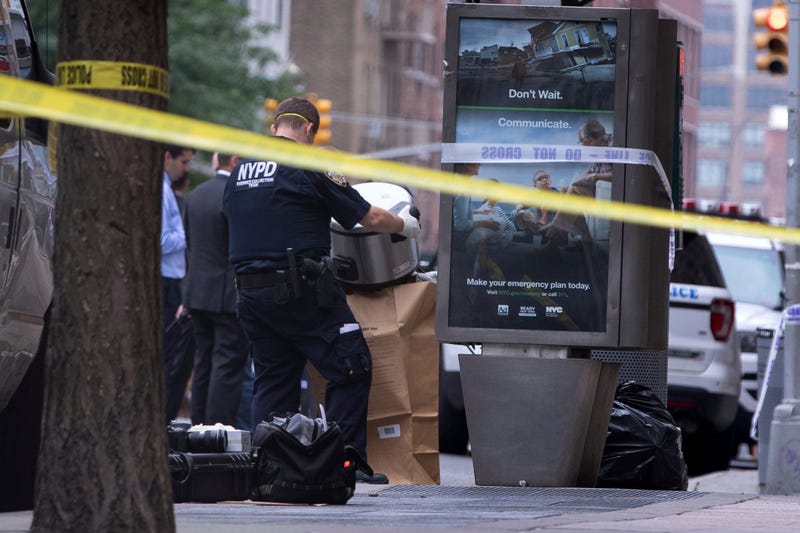 An investigator bags a suspicious package as evidence after it was thought to be an explosive device in Manhattan's Chelsea neighborhood Friday, Aug. 16, 2019, in New York.