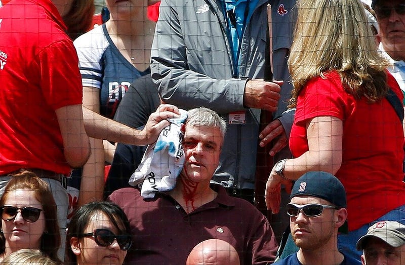 Fenway Park personnel attend to a fan who was hit by a broken bat