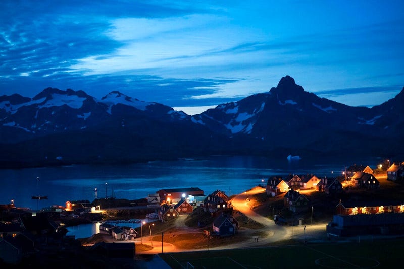 homes are illuminated after the sunset in Tasiilaq, Greenland. (