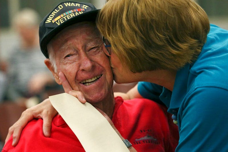 Alamo Honor Flights volunteer Elizabeth Montalvo kisses World War II veteran E.W. King, 94, before a ceremony