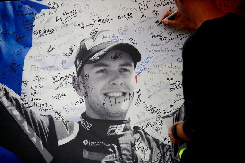 A man signs a remembrance board for Formula 2 driver Anthoine Hubert 
