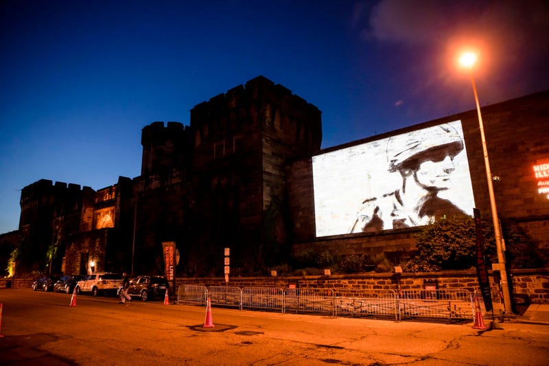 A guest film by Dee Hibbert-Jones and Nomi Talisman, titled "Last Day of Freedom" is projected on the wall of Eastern State Penitentiary in Philadelphia.