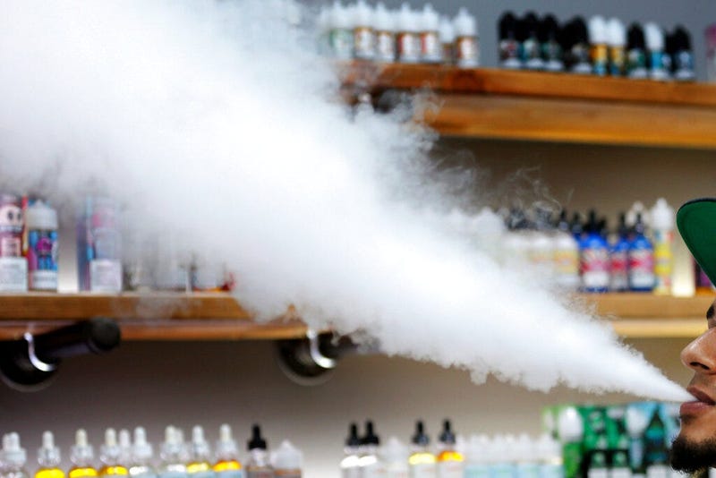 A salesman at a vape shop exhales while using an e-cigarette in Maine.