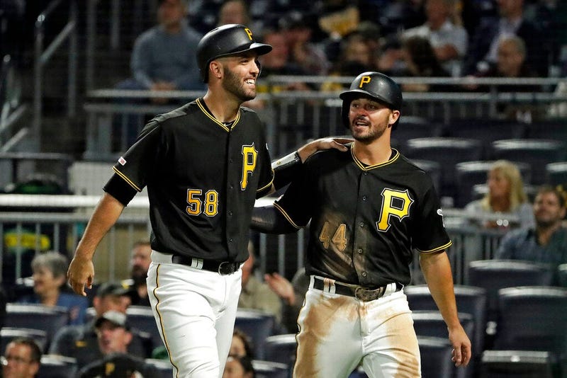 Pittsburgh Pirates' Kevin Kramer (44) and Jacob Stallings return to the dugout after scoring on a single by Erik Gonzalez off Chicago Cubs starting pitcher Kyle Hendricks during the seventh inning of a baseball game in Pittsburgh, Tuesday, Sept. 24, 2019.