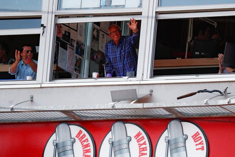 Cincinnati Reds announcer Marty Brennaman, center, waves to the crowd after the close of the fourth inning of a baseball game against the Milwaukee Brewers, Thursday, Sept. 26, 2019, in Cincinnati. (