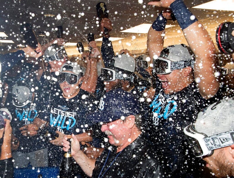 Tampa Bay Rays players celebrate in the clubhouse after they defeated the Toronto Blue Jays and clinched an MLB American League wild-card berth in Toronto, Friday, Sept. 27, 2019. 