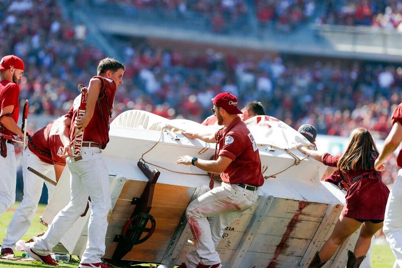 The Oklahoma Sooner Schooner flipped over during a touchdown celebration on the field during the first half of an NCAA college football game against West Virginia in Norman, Okla., Saturday, Oct. 19, 2019.