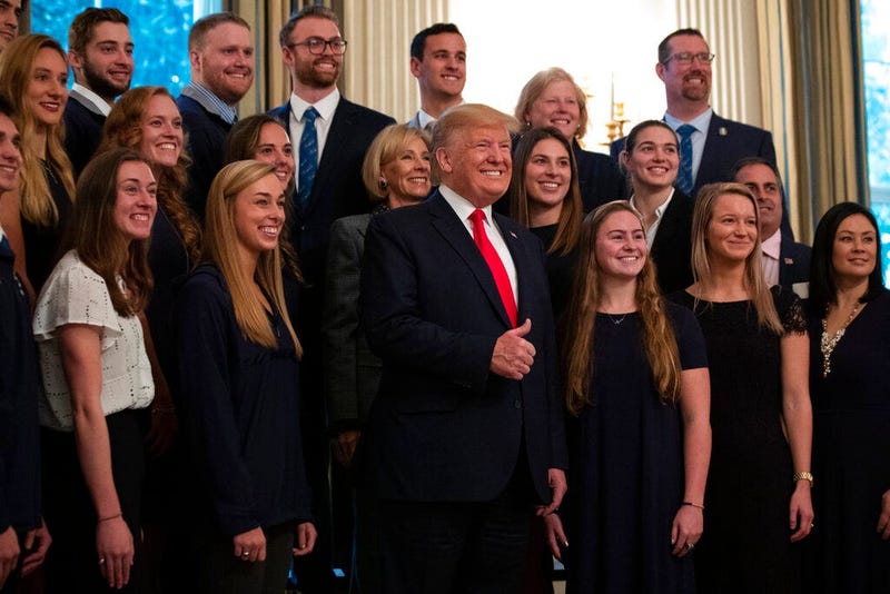 President Donald Trump stands with members of Queens University of Charlotte Swim Team during the NCAA Collegiate National Champions Day at the White House, Friday, Nov. 22, 2019, in Washington.