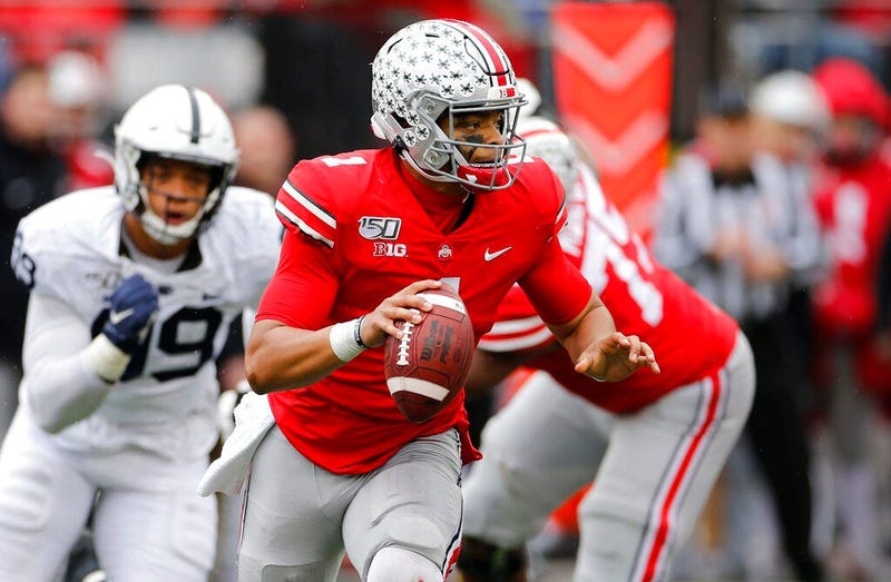 Ohio State quarterback Justin Fields, right, looks for an open receiver as Penn State defensive lineman Yetur Gross-Matos chases him during the second half of an NCAA college football game Saturday, Nov. 23, 2019, in Columbus, Ohio. Ohio State beat Penn S