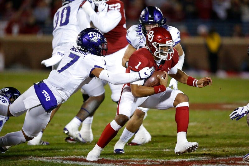 Oklahoma quarterback Jalen Hurts (1) carries past TCU safety Trevon Moehrig (7) and linebacker Garret Wallow (30) in the first quarter of an NCAA college football game in Norman, Okla., Saturday, Nov. 23, 2019.