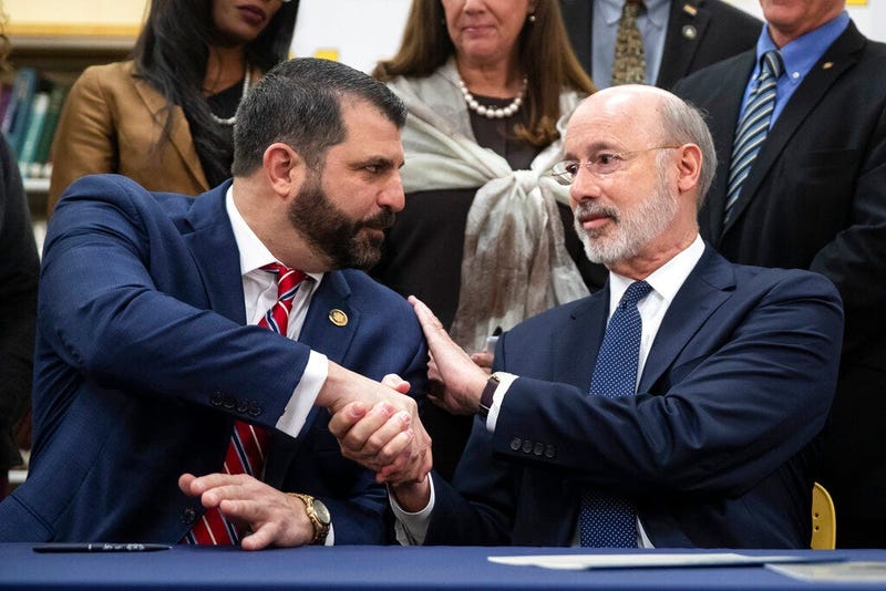 Pennsylvania Gov. Tom Wolf, right, shakes hands with Rep. Mark Rozzi, D-Berks, after signing legislation into law at Muhlenberg High School in Reading, Pa., Tuesday, Nov. 26, 2019. Wolf approved legislation Tuesday to give future victims of child sexual a