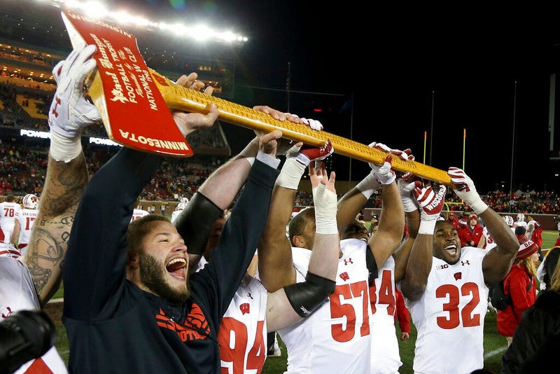 Wisconsin players hold up Paul Bunyan's Axe up after winning 31-0 against Minnesota