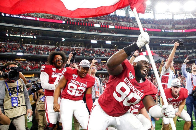 Oklahoma defensive lineman Neville Gallimore (90) plants a University of Oklahoma flag after the Sooners 30-23 overtime win over Baylor in an NCAA college football game for the Big 12 Conference championship, Saturday, Dec. 7, 2019, in Arlington, Texas.