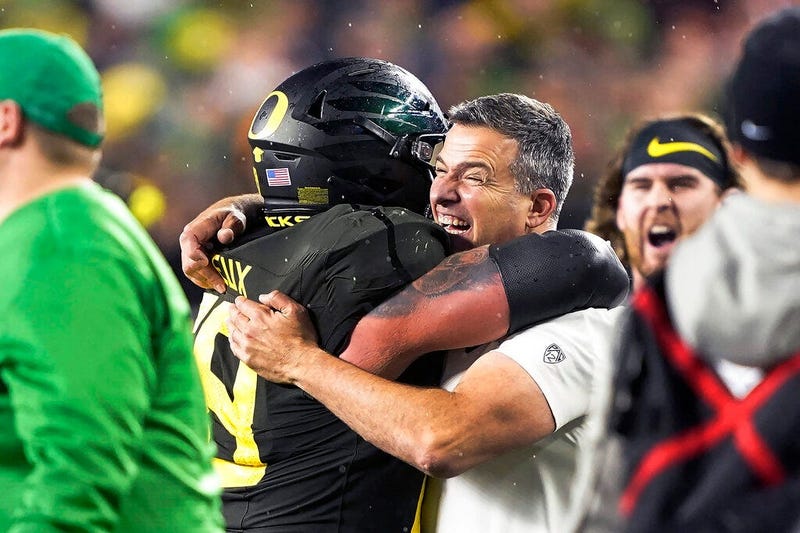 Oregon coach Mario Cristobal, right, celebrates with offensive lineman Shane Lemieux 