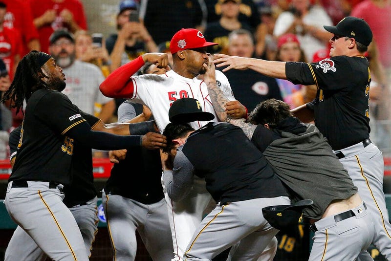 Cincinnati Reds relief pitcher Amir Garrett (50) looks to throw a punch as he is held back by a number of Pittsburgh Pirates players during a brawl in the ninth inning of a baseball game in Cincinnati, July 30, 2019.