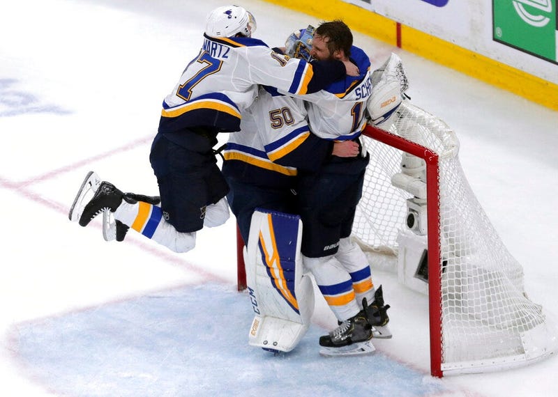 St. Louis Blues' Jaden Schwartz, left, and Brayden Schenn, right, mob goaltender Jordan Binnington, to celebrate their win over the Boston Bruins in Game 7 of the NHL hockey Stanley Cup Final, June 12, 2019, in Boston. 