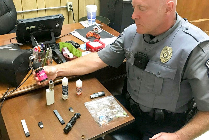 Police Officer Marlin Goff shows some of the vaping products he has confiscated from students at a high school
