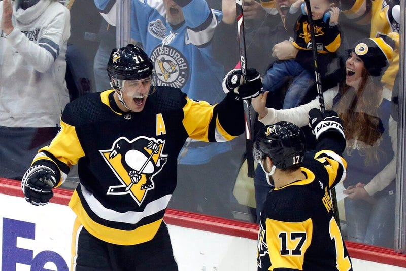 Pittsburgh Penguins' Evgeni Malkin (71) celebrates with Pittsburgh Penguins' Bryan Rust (17) after scoring against the Ottawa Senators during the first period of an NHL hockey game, Monday, Dec. 30, 2019, in Pittsburgh.