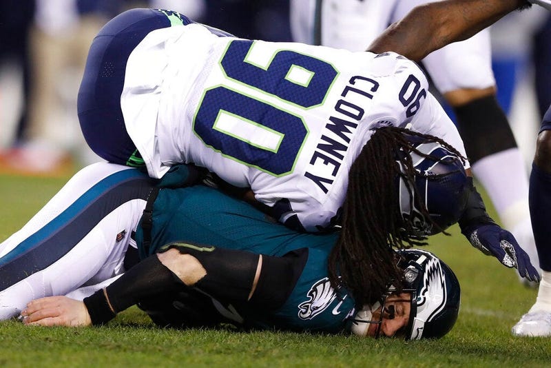 Philadelphia Eagles' Carson Wentz (11) is hit by Seattle Seahawks' Jadeveon Clowney (90) during the first half of an NFL wild-card playoff football game, Sunday, Jan. 5, 2020, in Philadelphia.