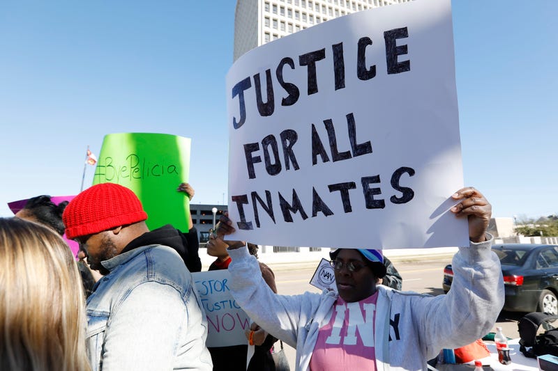 Prisoner advocates hold signs supporting inmate rights at a protest outside the Capitol in Jackson, Miss., Tuesday, Jan. 7, 2020.