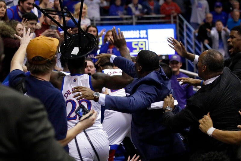 A fight between players spills into the crowd during the second half of an NCAA college basketball game between Kansas and Kansas State in Lawrence, Kan., 