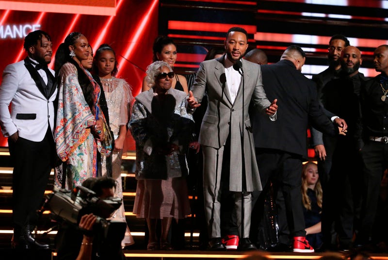John Legend, center, DJ Khaled and members of Nipsey Hussle's family accept the award for best rap/sung performance at the 62nd annual Grammy Awards on Sunday, Jan. 26, 2020, in Los Angeles.