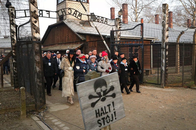 Poland's President Andrzej Duda walks along with survivors through the gates of the Auschwitz Nazi concentration camp to attend the 75th anniversary of its liberation in Oswiecim, Poland, Monday, Jan. 27, 2020.