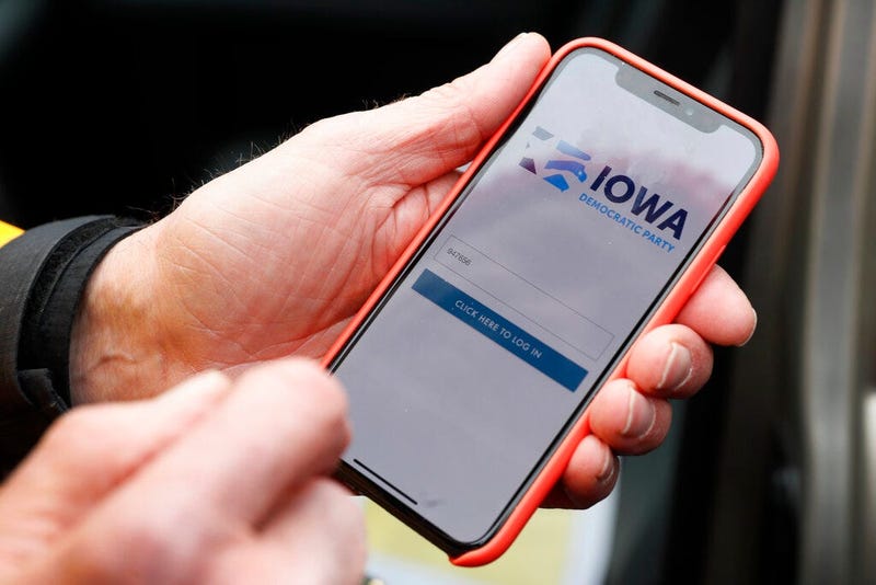 Precinct captain Carl Voss, of Des Moines, Iowa, holds his iPhone that shows the Iowa Democratic Party's caucus reporting app Tuesday, Feb. 4, 2020, in Des Moines, Iowa.