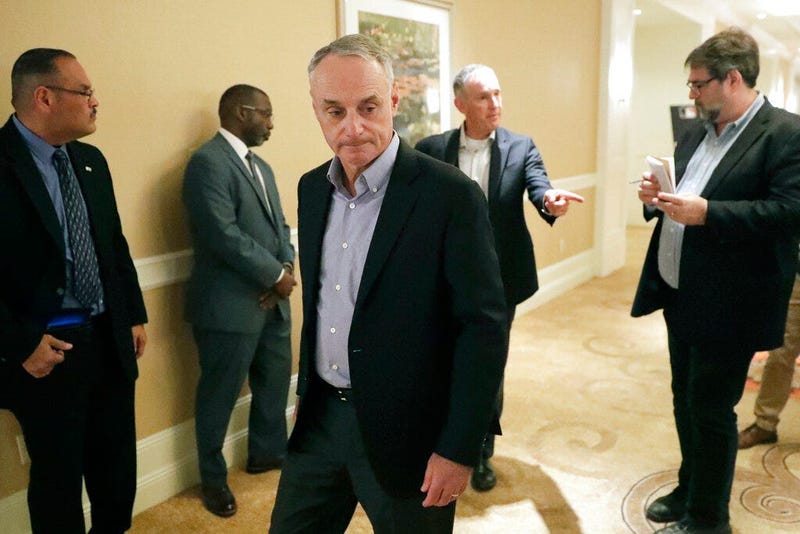 MLB Commissioner Rob Manfred, center, leaves a press conference during MLB baseball owners meetings, Thursday, Feb. 6, 2020, in Orlando, Fla.