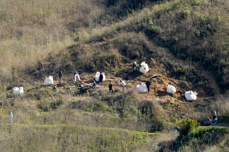 In this Tuesday, Jan. 28, 2020, file photo, investigators work at the scene of a helicopter crash that killed former NBA basketball player Kobe Bryant, his 13-year-old daughter, Gianna, and seven others, in Calabasas, Calif.