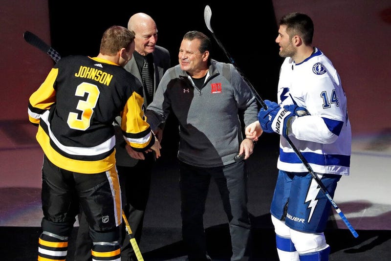 Mike Eruzione, center right, captain of the 1980 U.S men's hockey team, and assistant coach Craig Patrick, center left, participate in a ceremonial face off between Pittsburgh Penguins' Jack Johnson (3) and Tampa Bay Lightning's Pat Maroon (14) to commemo