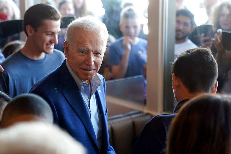 Democratic presidential candidate former Vice President Joe Biden talks with customers people watch through the window's at the Buttercup Diner during a campaign stop in Oakland, Calif., Tuesday, March 3, 2020.