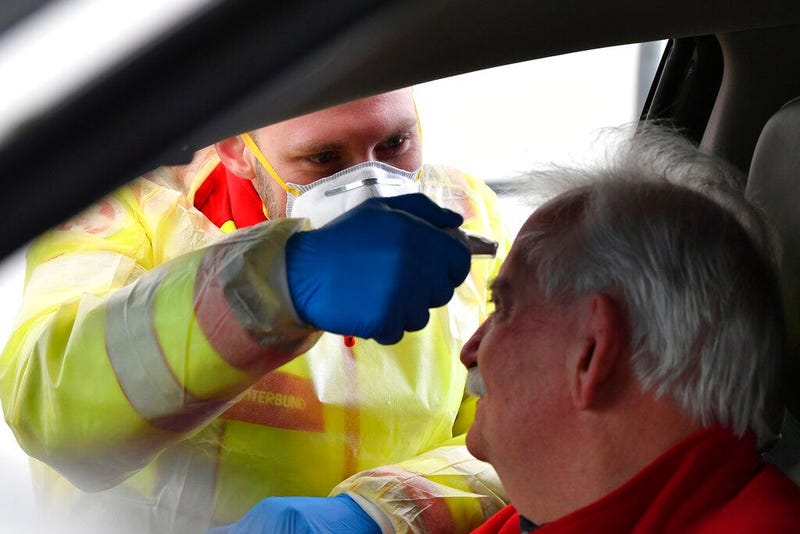 A member of the medical staff measures the temperature of a traveller at a autobahn park place near Gries am Brenner, Austrian province of Tyrol, at border crossing with Italy on Tuesday, March 10, 2020. (AP Photo/Kerstin Joensson )