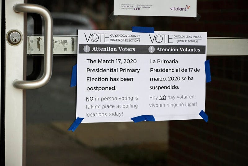 A sign is taped to a door leading into a polling location at the Messiah Lutheran Church, Tuesday, March 17, 2020, in Lyndhurst, Ohio. Ohio called off its presidential primary just hours before polls were set to open there and in three other states, an 11
