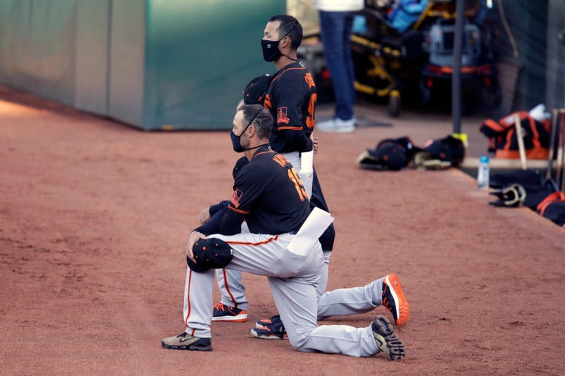 San Francisco Giants' manager Gabe Kapler kneels during the national anthem prior to an exhibition baseball game against the Oakland Athletics, Monday, July 20, 2020, in Oakland, Calif.