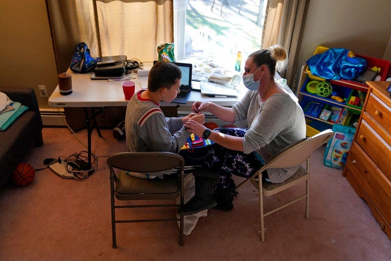 Paraprofessional Jessica Wein helps Josh Nazzaro stay focussed while attending class virtually from his home in Wharton, N.J., Wednesday, Nov. 18, 2020.  (AP Photo/Seth Wenig)