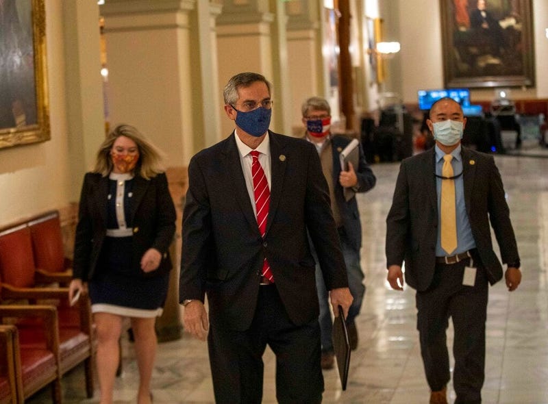 Georgia Secretary of State Brad Raffensperger, center, walks with members of his staff as they make their way to a press conference at the Georgia State Capitol building in Atlanta.  (Alyssa Pointer/Atlanta Journal-Constitution via AP)