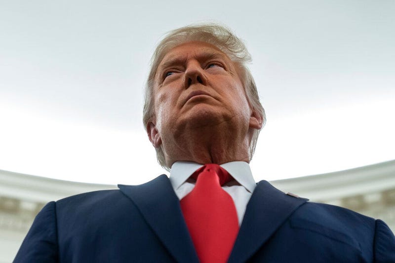 President Donald Trump listens during a ceremony to present the Presidential Medal of Freedom to former football coach Lou Holtz, in the Oval Office of the White House, Thursday, Dec. 3, 2020, in Washington. (AP Photo/Evan Vucci)
