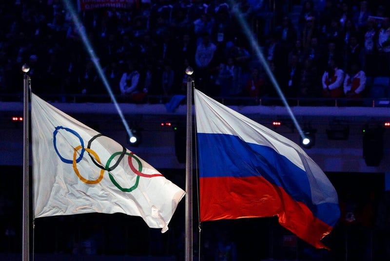 FILE - In this Feb. 23, 2014 file photo the Russian national flag, right, flies after it is hoisted next to the Olympic flag during the closing ceremony of the 2014 Winter Olympics in Sochi, Russia.