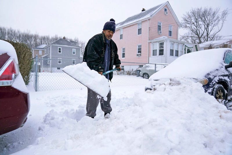 Barry James digs out his car, as well as his daughter's car, before trying to get to work in Englewood, N.J., Thursday, Dec. 17, 2020.