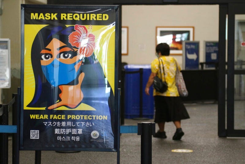 FILE - In this Oct. 2, 2020 file photo, a woman walks into the international airport in Honolulu amid a quarantine rule that effectively shut down the tourism industry in the state.