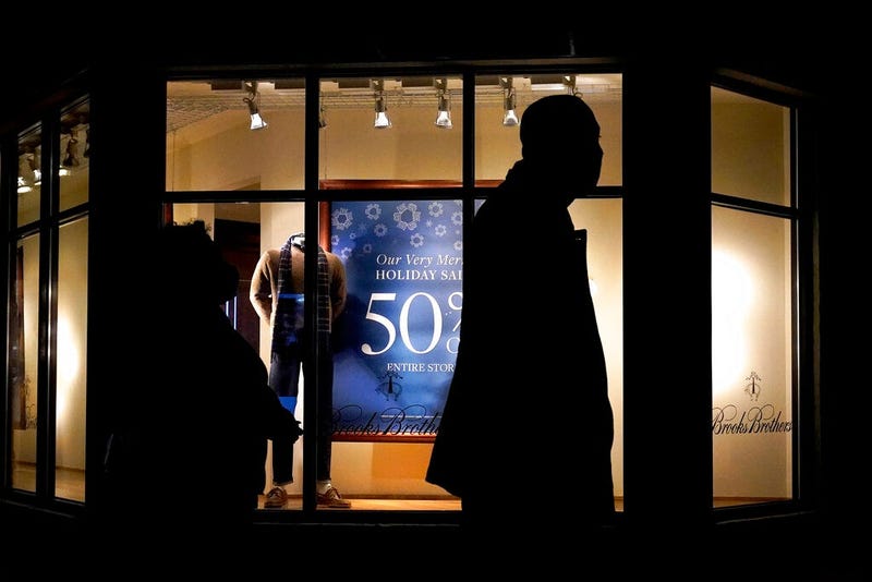 In this Saturday, Dec. 19, 2020 file photo, people walk past the window display of a store in Skokie, Ill. (AP Photo/Nam Y. Huh)