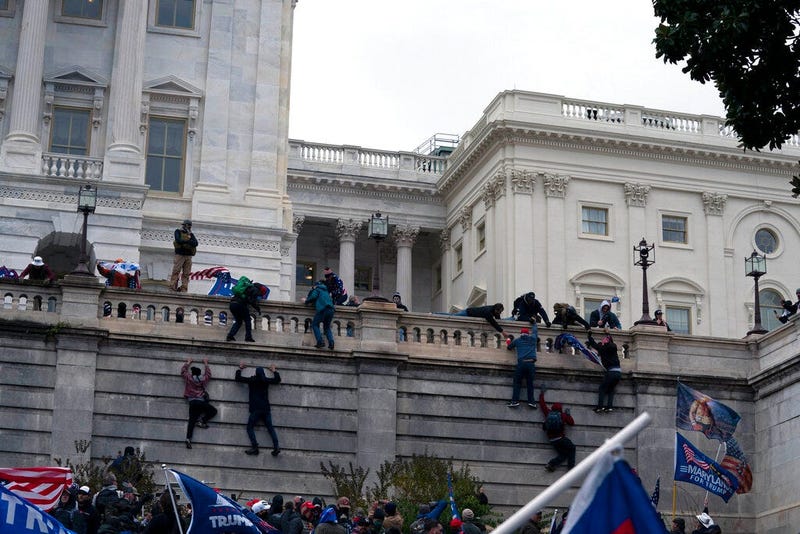 Supporters of President Donald Trump climb the West wall of the the U.S. Capitol on Wednesday, Jan. 6, 2021, in Washington. 