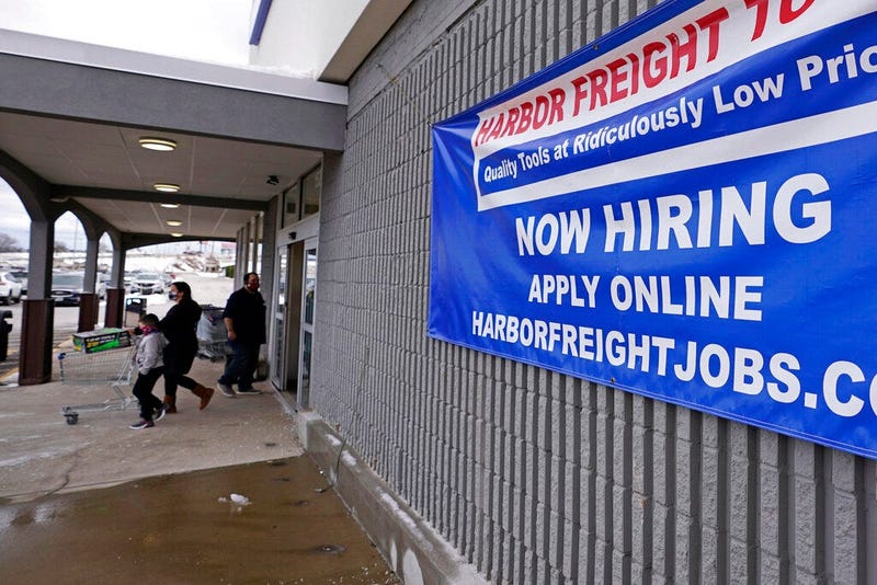 In this Dec. 10, 2020, file photo, a "Now Hiring" sign hangs on the front wall of a Harbor Freight Tools store in Manchester, N.H. (AP Photo/Charles Krupa, File)