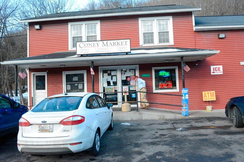 A patron approaches the entrance to Coney Market, a convenience store Lonaconing, Md., where the jackpot-winning Powerball ticket worth $731.1 million was sold in a struggling coal mining town.  (Steven Bittner/Cumberland Times-News via AP)