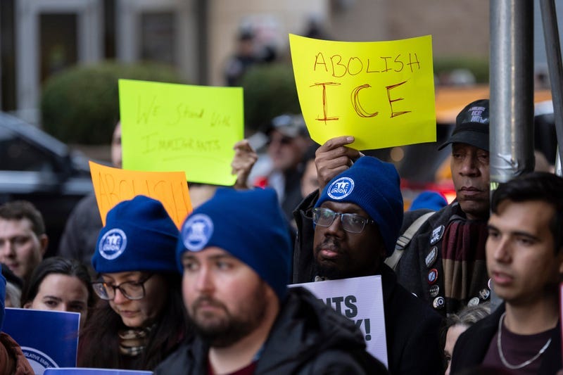 People raise signs in support of immigrants during a news conference outside Greater New York Federal Building, Tuesday, Jan. 13, 2026, in New York