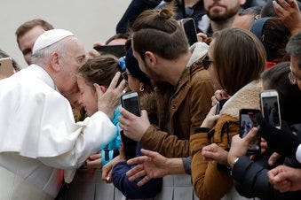 Pope Francis kisses a child in St. Peter's Square at the Vatican before leaving after his weekly general audience, Wednesday, Feb. 26, 2020. (AP Photo/Alessandra Tarantino)